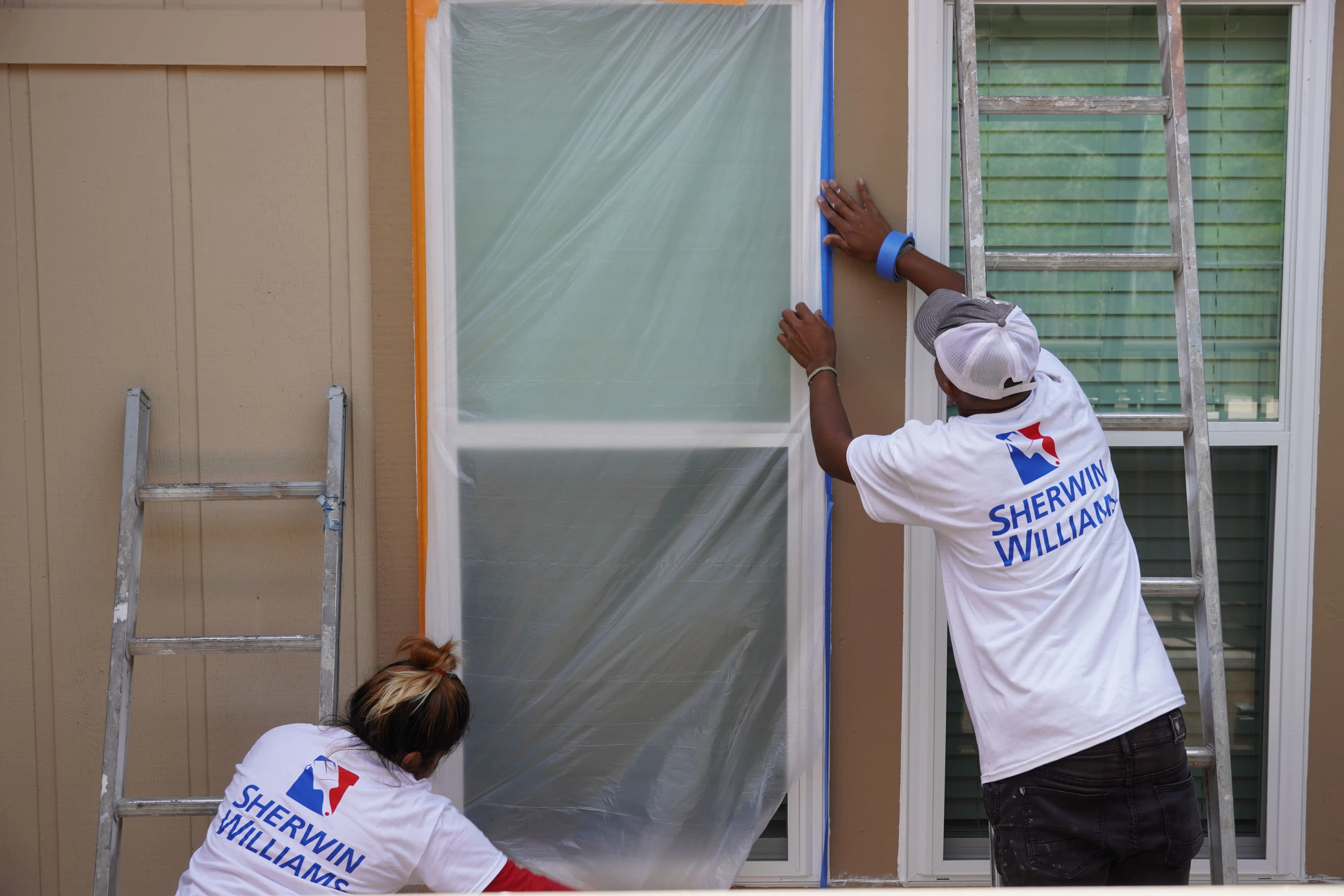 Swift Painting crew masking and prepping windows before painting